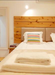 塔维拉Casa do Arco by HnM的卧室配有一张白色大床和木制床头板