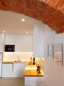 塔维拉Casa do Arco by HnM的厨房配有白色橱柜和木制台面