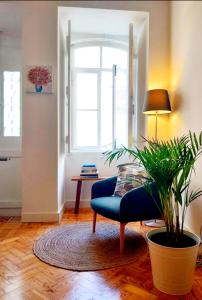 塔维拉Casa do Arco by HnM的客厅配有蓝色沙发和植物