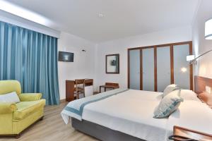 塞图巴尔阿兰格斯酒店的酒店客房,配有床和黄色椅子