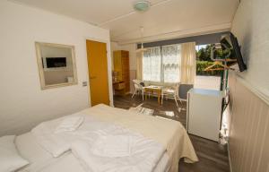 罗莫柯克比科曼多伽登酒店的一间带一张床的房间和一间带桌子的用餐室