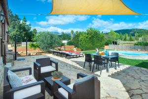坎帕内特Owl Booking Villa Garreta - Rustic Stay with Mountain Views的一个带桌椅的庭院和一个游泳池