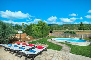 坎帕内特Owl Booking Villa Garreta - Rustic Stay with Mountain Views的一个带躺椅的庭院和一个游泳池