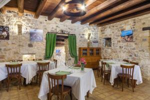 BuccheriMasseria Fortificata Lo Zafferaneto的石墙内带桌椅的餐厅