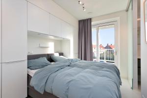 卡德赞德Modern appartement met doorkijk op de duinen的一间卧室设有一张大床和一个窗户。