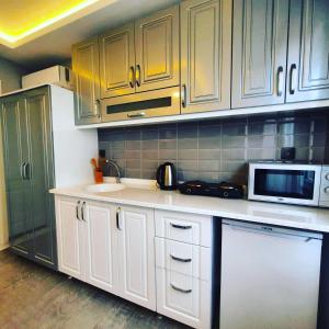 伊斯坦布尔Ararat Apart的厨房配有白色橱柜和微波炉