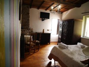 潘通Casa dos Muros turismo rural y actividades en la Ribeira Sacra的卧室配有一张床和一张桌子