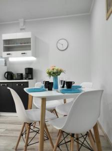 凯尔德拉Hiiumaa Family Apartments的白色餐桌和白色椅子