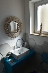 斯佩隆加CàSolare Country House的浴室设有白色水槽和镜子