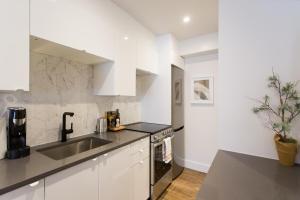 蒙特利尔Scandinavian Studio with Full Kitchen and Bath by Den Stays的白色的厨房设有水槽和台面