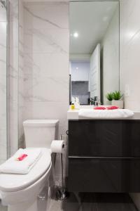 蒙特利尔Scandinavian Studio with Full Kitchen and Bath by Den Stays的浴室设有白色的卫生间和镜子