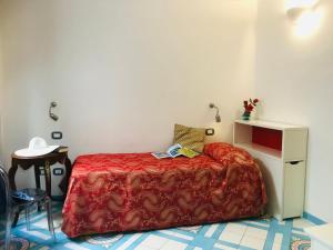 阿马尔菲克罗齐迪阿马尔菲酒店的一间小卧室,配有一张带红色毯子的床