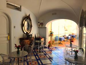 阿马尔菲克罗齐迪阿马尔菲酒店的配有桌椅和镜子的房间