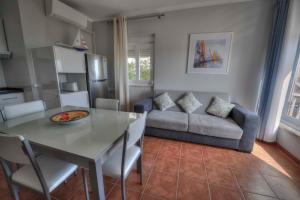波尔蒂芒Apartamentos Belo Horizonte的厨房以及带桌子和沙发的客厅。
