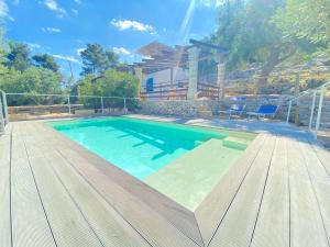 科尔萨诺Villa Aurora的一个带木制甲板和房子的大型游泳池