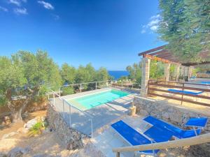 科尔萨诺Villa Aurora的一座房子旁的游泳池,配有蓝色的椅子