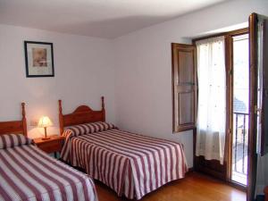 托尔拉Apartamento Miguel Torla Ordesa的一间卧室设有两张床,窗户设有门