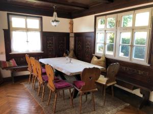 巴特特尔茨Schatzl Hütte的一间带桌椅和窗户的用餐室