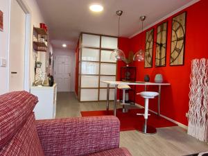 卢戈Apartamento Centro Frente Muralla 2的客厅设有红色的墙壁和桌子