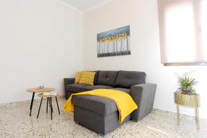 罗德镇Alion House的客厅配有带黄色毯子的灰色沙发