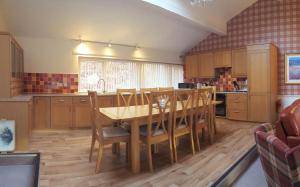 金洛赫兰诺赫Loch Rannoch Highland Lodge 44的厨房配有木桌和木椅
