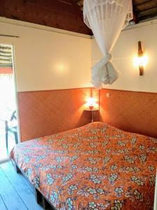 法勒HUAHINE - Bungalow Vanille 2p的一间卧室配有床和窗帘