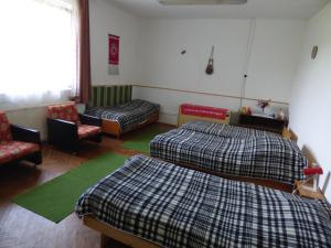 AlsóbereckiÁGÓC Vendégház的一间设有两张床、一张沙发和一把椅子的房间