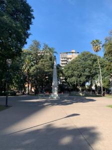 圣米格尔·德·图库玛Monoambiente Plaza Belgrano的一座树木繁茂的公园中央的雕像