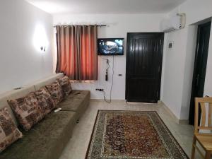 赫尔格达Chalet at Stella Di Mare Makadi Bay的带沙发和电视的客厅以及门
