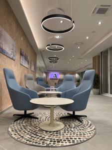 内乌姆Marea Hotel & Spa的一间会议室,配有蓝色的椅子和桌子
