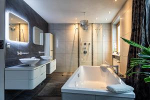 滨湖采尔Apartment Lisa的浴室配有两个盥洗盆和浴缸。