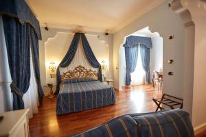 丘西Hotel Villa Il Patriarca的一间卧室配有一张蓝色天蓬床