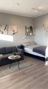 Ytri-NjarðvíkBergOne的一间卧室配有一张床、一张沙发和一张桌子