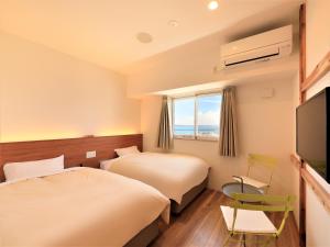 宫古岛Central Resort Miyakojima的酒店客房设有两张床和一台平面电视。