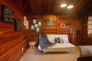 韦尔卡鲍Casinha de Madeira no Vale do Capão的客厅配有沙发,客厅设有木墙