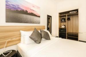 悉尼格兰佛里旅馆的卧室配有白色的床和墙上的绘画作品