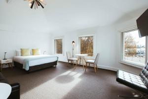 霍巴特Salamanca Galleria Apartments的卧室配有一张床和一张桌子及椅子