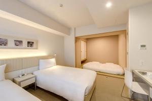京都馨乐庭京都乌丸五条酒店的酒店客房设有两张床和盥洗盆