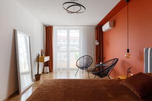 伊万诺-弗兰科夫斯克Roof Rooms的一间卧室配有两把椅子和橙色墙壁