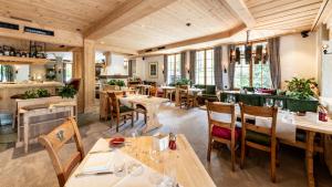 格施塔德乐格兰德小木屋格尼塞尔酒店的餐厅设有木制天花板和桌椅