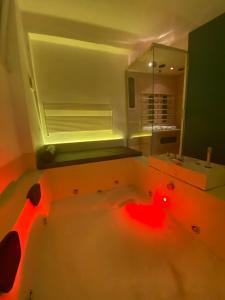 阿尔塔穆拉Suite61的一间带红色照明的大浴缸的浴室