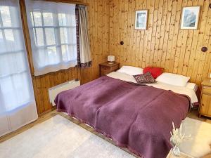 南达Chalet Belle Poncke的一间卧室配有一张带紫色毯子的床
