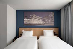 首尔Travelodge Myeongdong City Hall的墙上有两张照片的房间