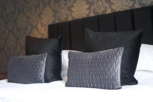 Llansantffraid Glyn Ceiriog格林谷酒店的一张带黑色枕头和白色床单的床