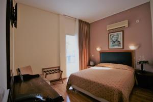 雅典亚当酒店的一间卧室配有一张床、一张桌子和一个窗户。
