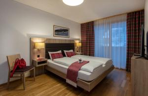 布赖尔布里格尔斯普拉达斯度假公寓的一间卧室配有一张床铺,床上铺有红色毯子
