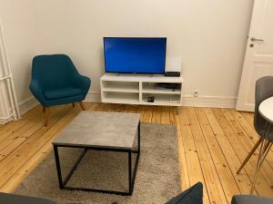 哥本哈根Randersgade的客厅配有电视和蓝椅