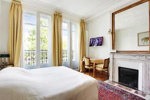 巴黎Suite junior avec balcon et vue sur Arc de Triomphe的一间卧室配有一张床和一个壁炉