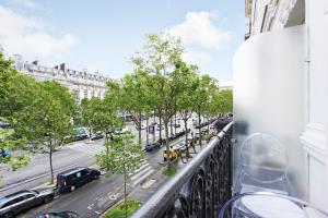 巴黎Suite junior avec balcon et vue sur Arc de Triomphe的阳台享有城市街道的景致。