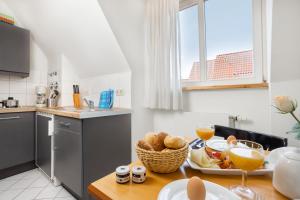 施特拉尔松德maakt Apartments的厨房里配有一张桌子,上面有盘子的食物